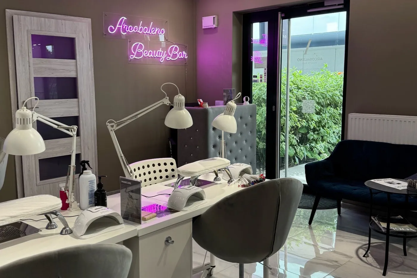 Wnętrze salonu Arcobaleno z neonem i stanowiskami do manicure